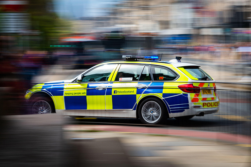 Motion Photo - A Blue Light Police Scotland BMW 330D Police Car Crosses Princes Street, Edinburgh, Scotland, UK. Emergency Response