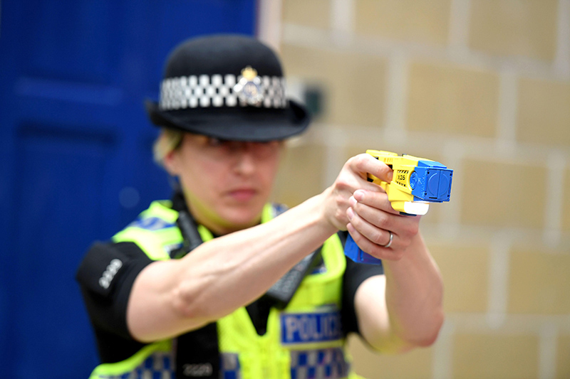 female police officer using a taser during training.