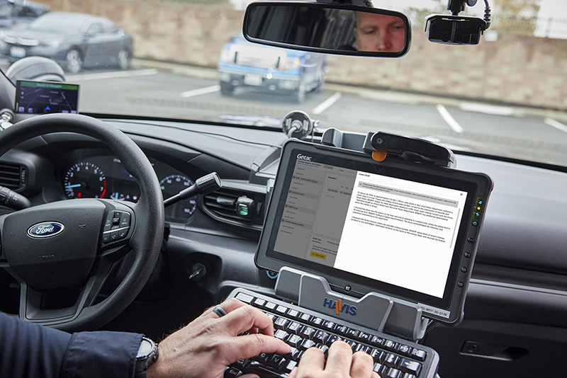 Officer typing on a keyboard using the Axon Draft One AI software
