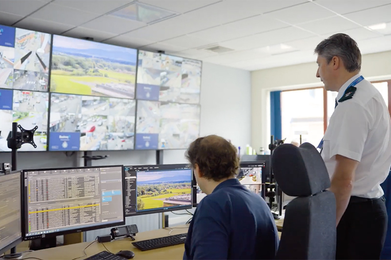 Ch Supt Carl Patrick, Cumbria Constabulary, with CCTV operator in front of a bank of CCTV screens