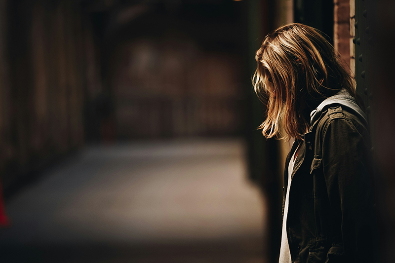 Female victim in dark alleyway