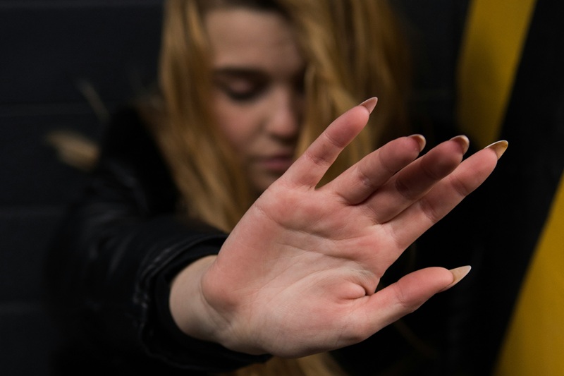 Woman in long black sleeve blocking with hand