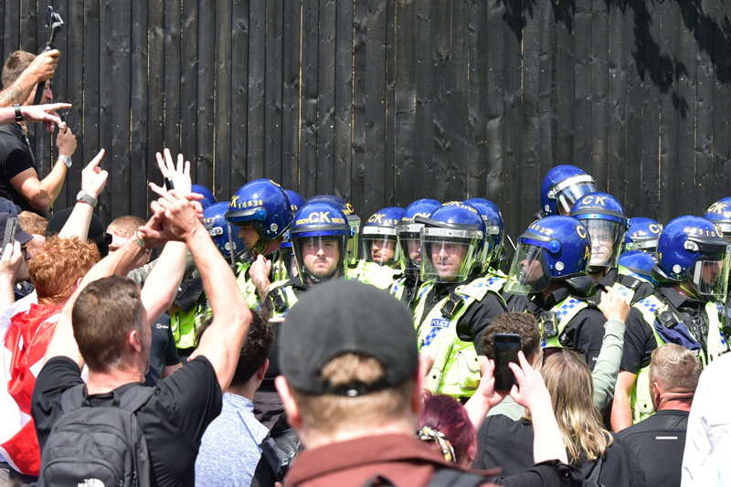 Manchester, UK, 3rd August, 2024. Stand off between riot police wearing helmets and right wing protesters.