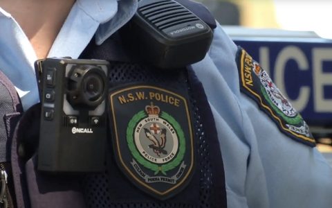 Close up of New South Wales Police Force badge and body-worn video camera