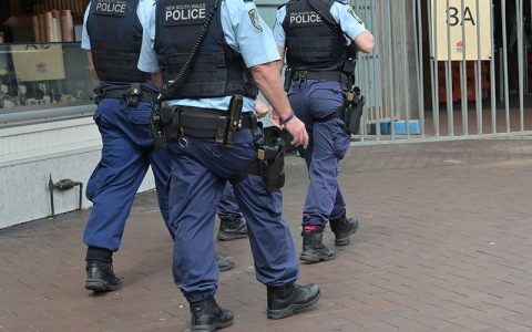 Unidentifiable NSW Police officers patrol with firearms