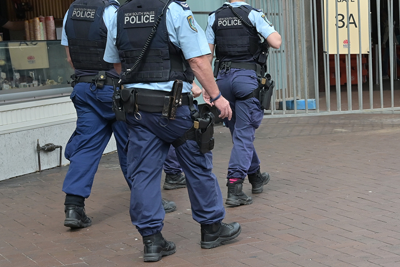Unidentifiable NSW Police officers patrol with firearms