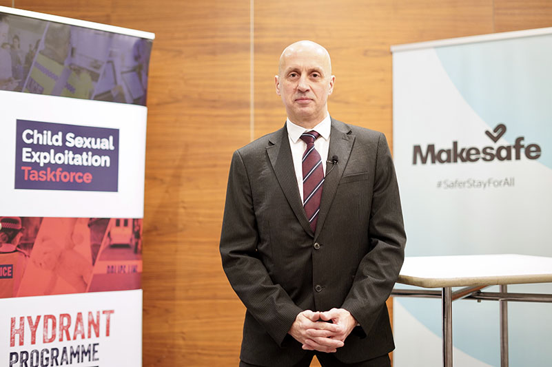 Richard Fewkes, Director of the Hydrant Programme and the CSE Taskforce, in front of promotional materials for the Taskforce and Operation Makesafe