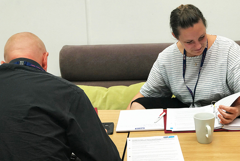 Two officers with Federation notebooks and lanyards – learning