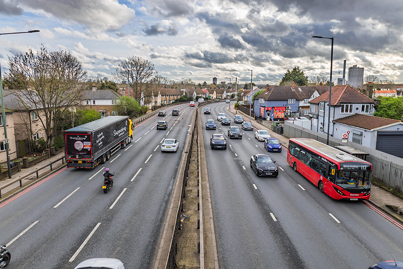 Busy urban multi lane highway with heavy traffic and trucks.