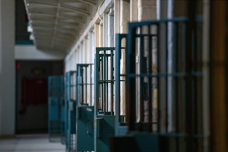 row of open doors of prison cells