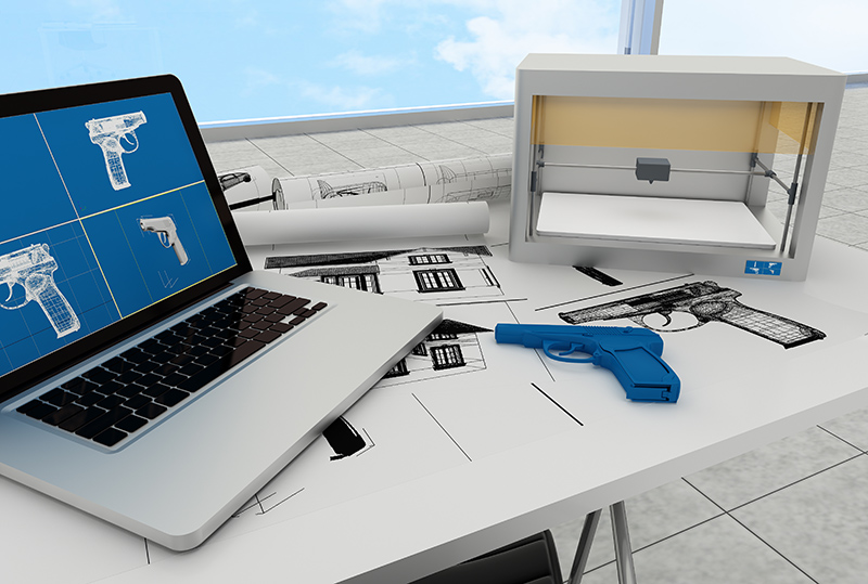 The image shows a workspace with blueprints of firearms, a laptop displaying gun designs, and a blue 3D-printed handgun, highlighting modern technology's role in policing and weapon design.