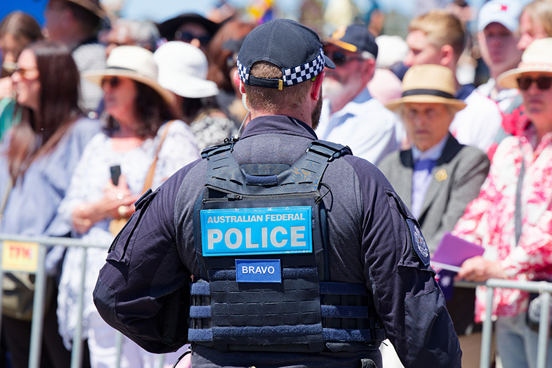 Australian Federal Police officer (rear view) facing crowd