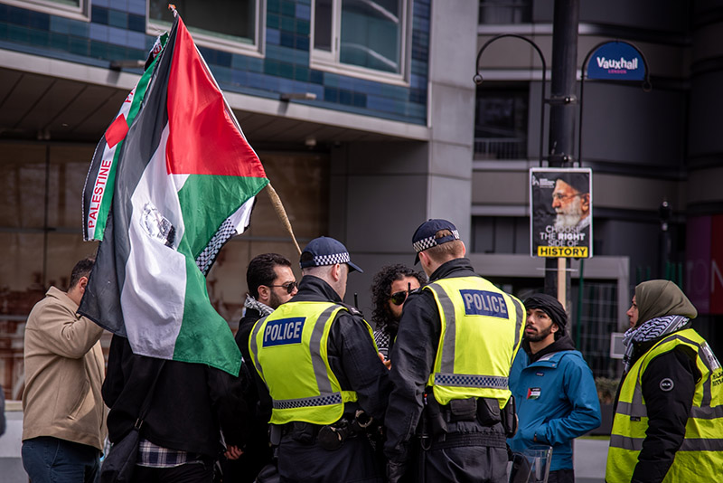 Police officers speak to protestors participating in the Al Quds Day Protest