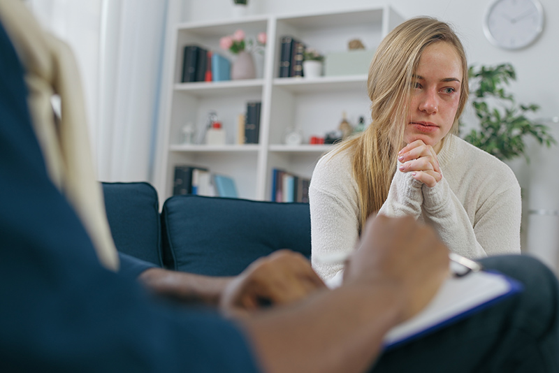 Scared woman trying to talk to psychologist about domestic violence, fear