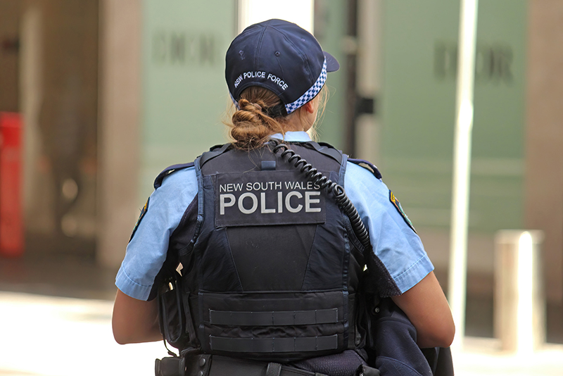 Rear view of an NSW police uniformed woman wearing a bullet proof vest