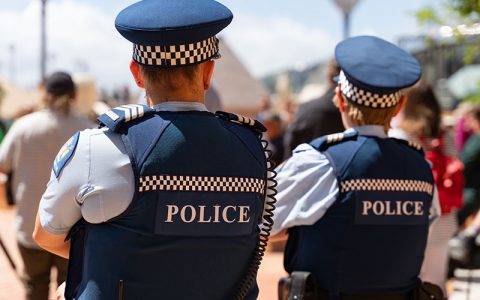 Two New Zealand Police officers on patrol, viewed from behind