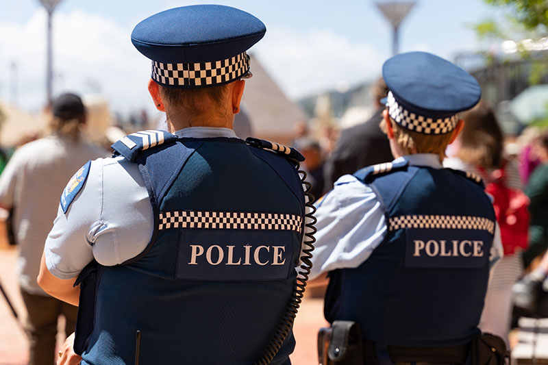 Two New Zealand Police officers on patrol, viewed from behind