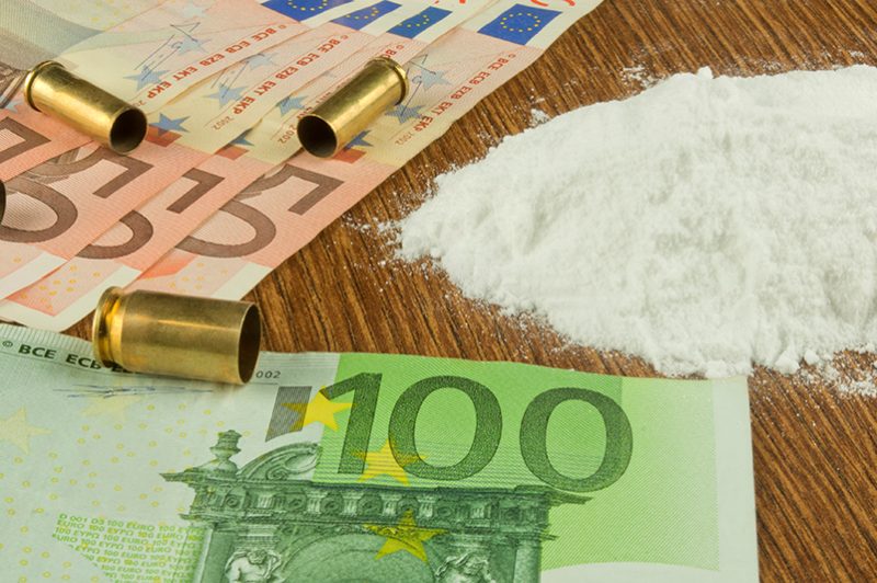 bullets, drugs and euros on a table, suggesting European organised crime