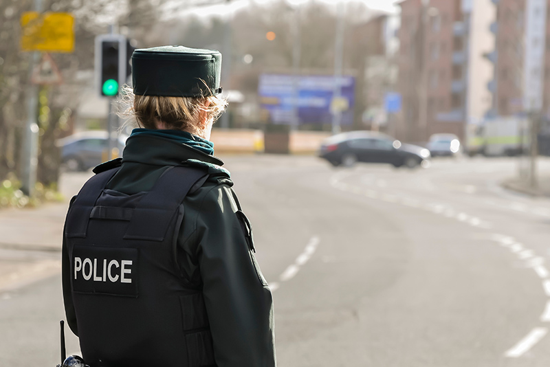 A police woman stands guard at a road in Belfast, while army ATOs defuse a bomb which was left in a residential area.