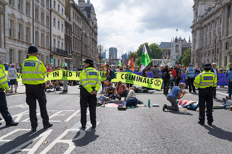 Extinction Rebellion protest down Whitehall in protest against HMRC and Barclays. Protestors with arms locked in tubes surrounded by the police.