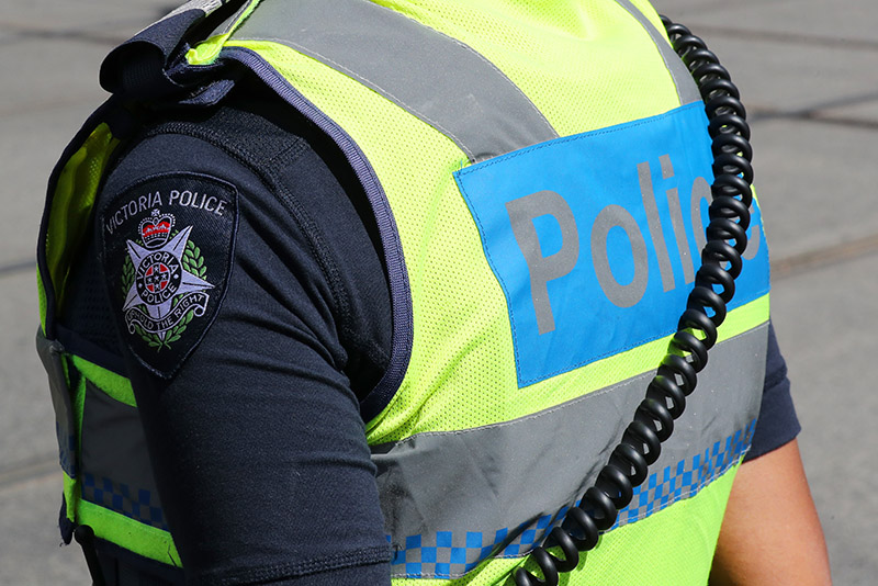 Rear view of a Victoria Police officer with shoulder patch