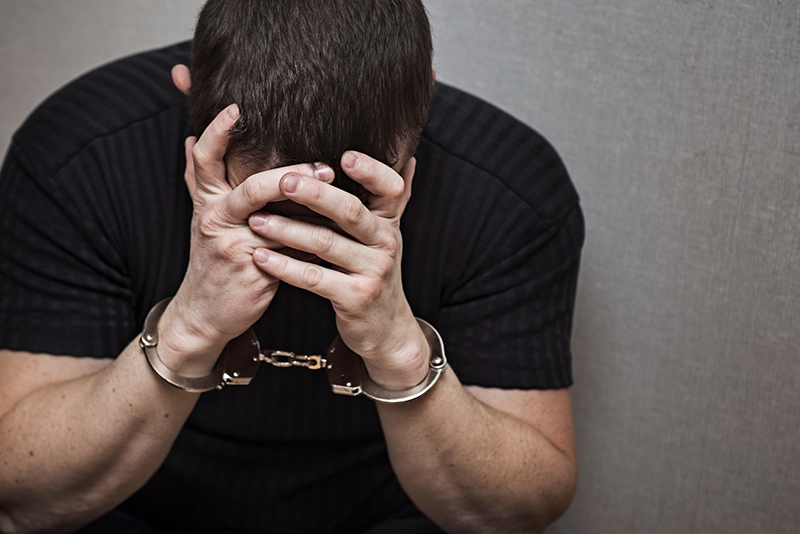 Distressed man in handcuffs in custody