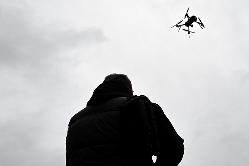 Drone is flying in the sky. Operator controls the drone.