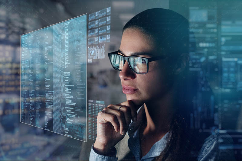 A black female financial investigator in her office reads financial news about the world economy on his futuristic newspaper in holography.