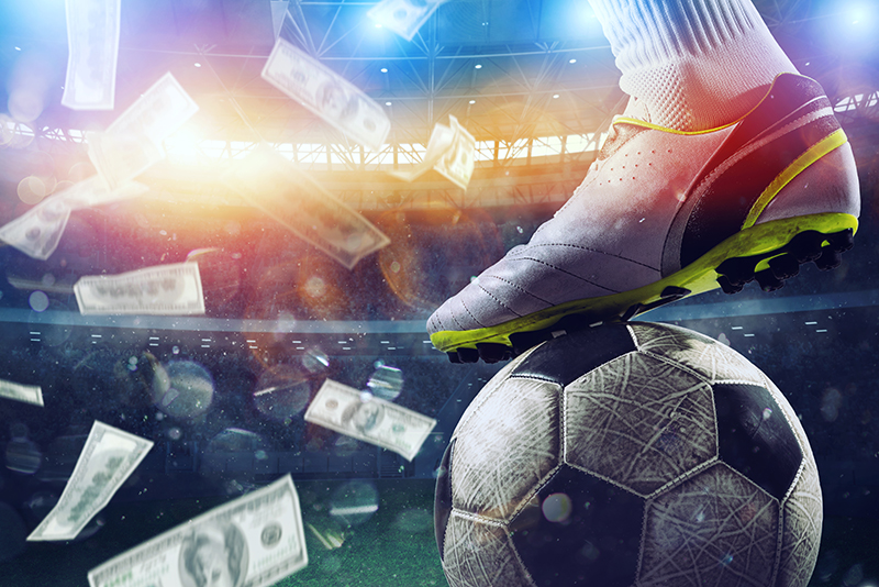 Soccer player's boot on a ball in a stadium with falling banknotes, signifying corruption in sport