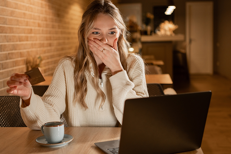 Shocked young woman with Empty bank card as money fraud result.