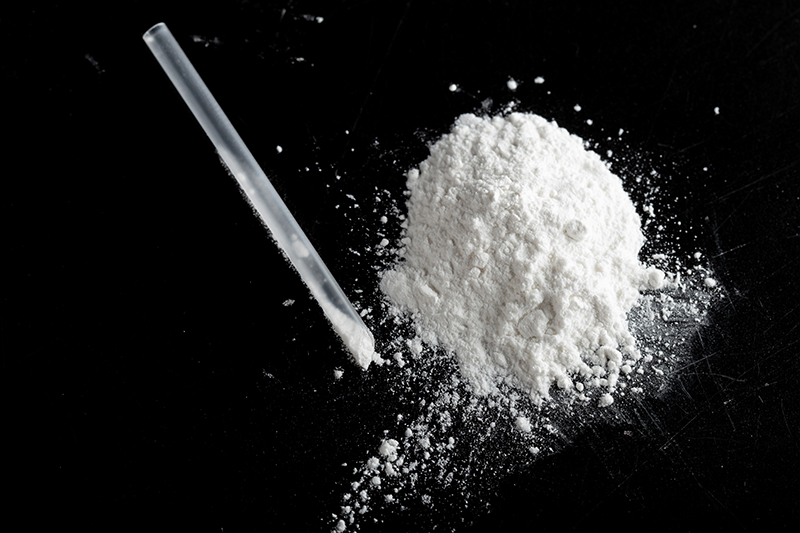 ketamine drugs and plastic straw on black wood background.Drug epidemic concept
