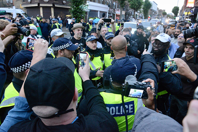 Cameras surrounding police officers at demonstration in London