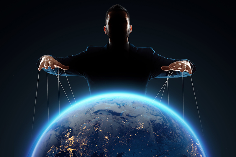 A man, a puppeteer, manipulates the planet.