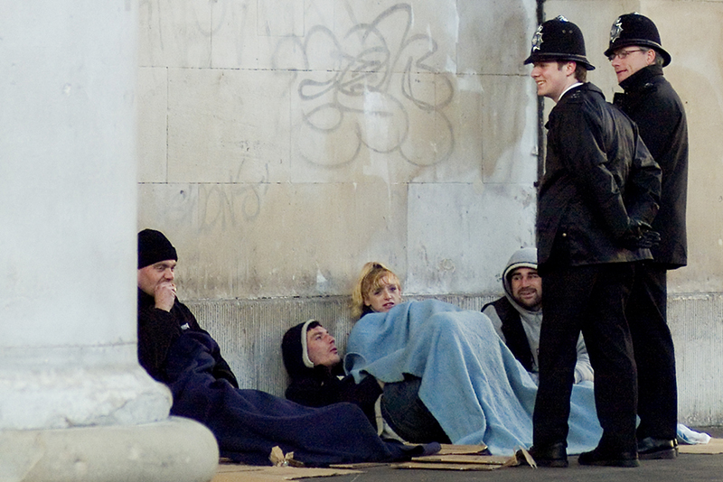 Policemen talking to rough sleepers in London's Covent Garden area