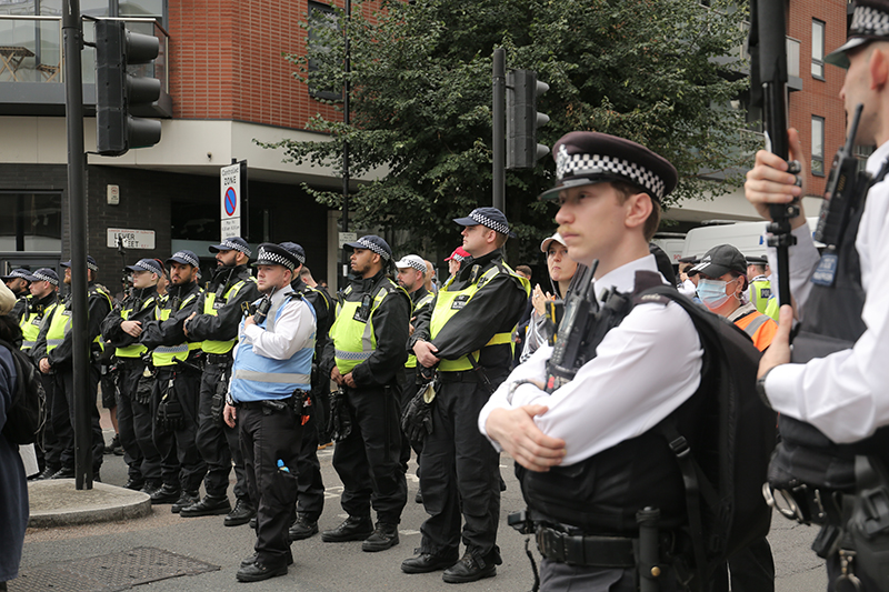 A line of police officers separating pro- and anti-migrant protesters outside the Thistle City Barbican Hotel