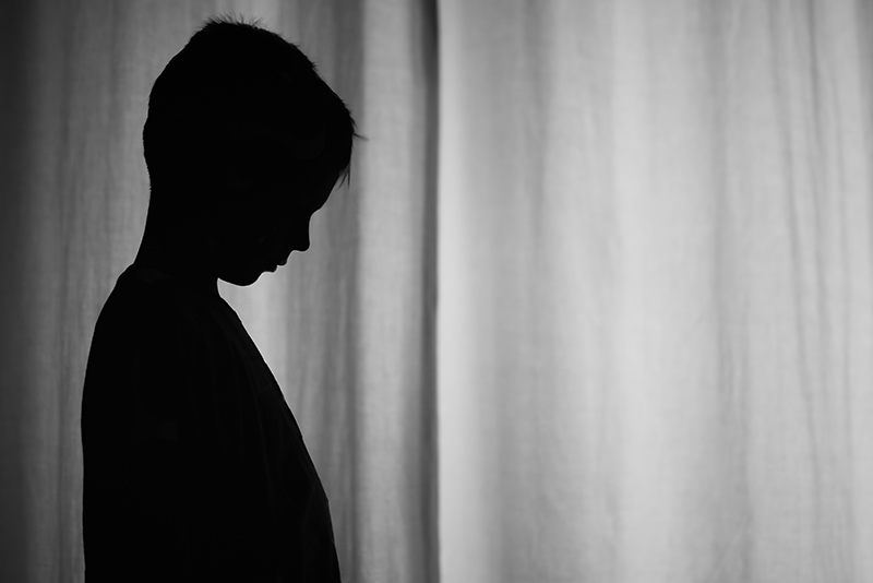 Silhouette of sad little boy