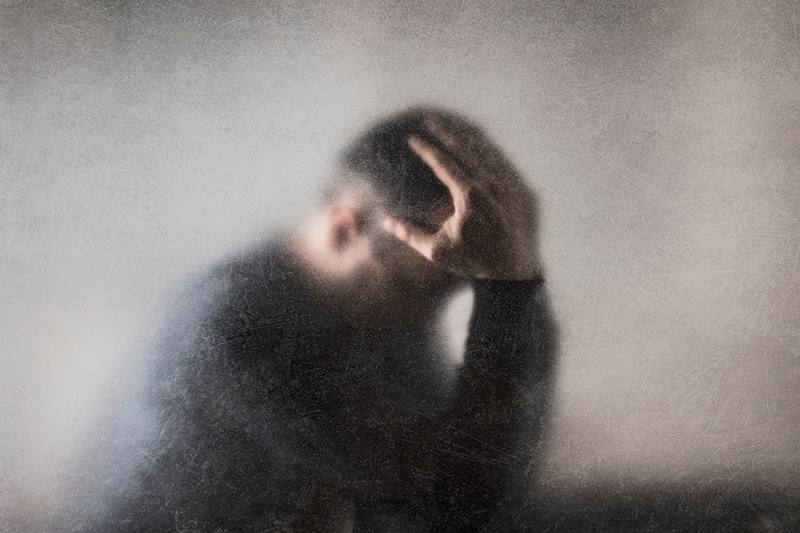 Depressed, broken man – male crime victims – behind a dusty scratched glass.