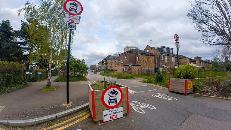 Planters, warning signs for vehicle traffic in a suburban Low Traffic Neighbourhood area.