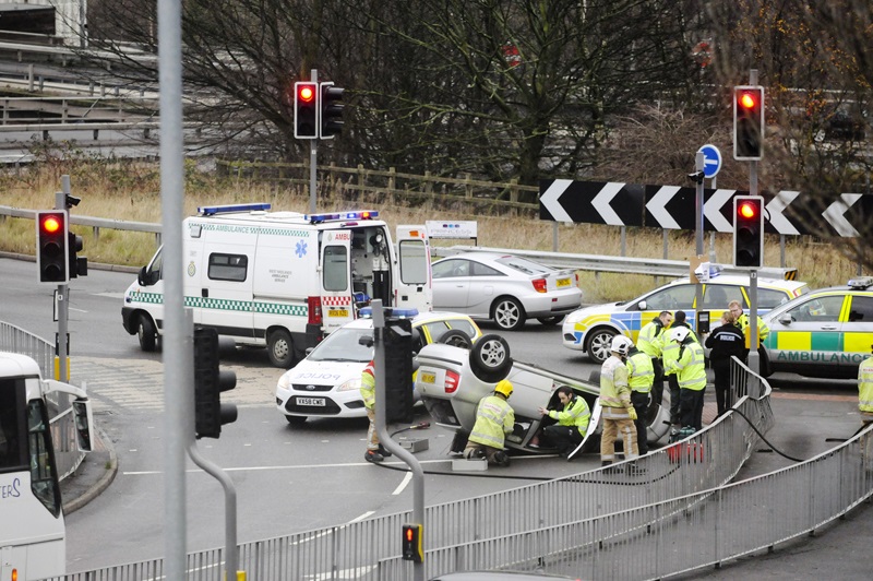 Stoke-on-Trent, England - December 20, 2011: Emergency services attend the scene of a road traffic accident where a car has overturned at a junction to a roundabout.