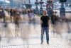 Man standing in a busy street, blurred background