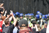 Manchester, UK, 3rd August, 2024. Stand off between riot police wearing helmets and right wing protesters.