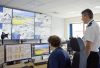 Ch Supt Carl Patrick, Cumbria Constabulary, with CCTV operator in front of a bank of CCTV screens