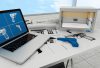 The image shows a workspace with blueprints of firearms, a laptop displaying gun designs, and a blue 3D-printed handgun, highlighting modern technology's role in policing and weapon design.