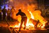 rioter throws brick at police line over fire