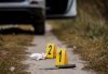 Crime scene investigation, bloody knife with crime markers on the ground, evidence of murder.
