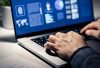 Pair of hands on laptop keyboard typing in data to an offender profile, signifying criminal case investigation