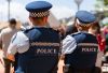 Two New Zealand Police officers on patrol, viewed from behind