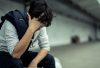 Stressed man (detective) sitting on a bench with head in hands